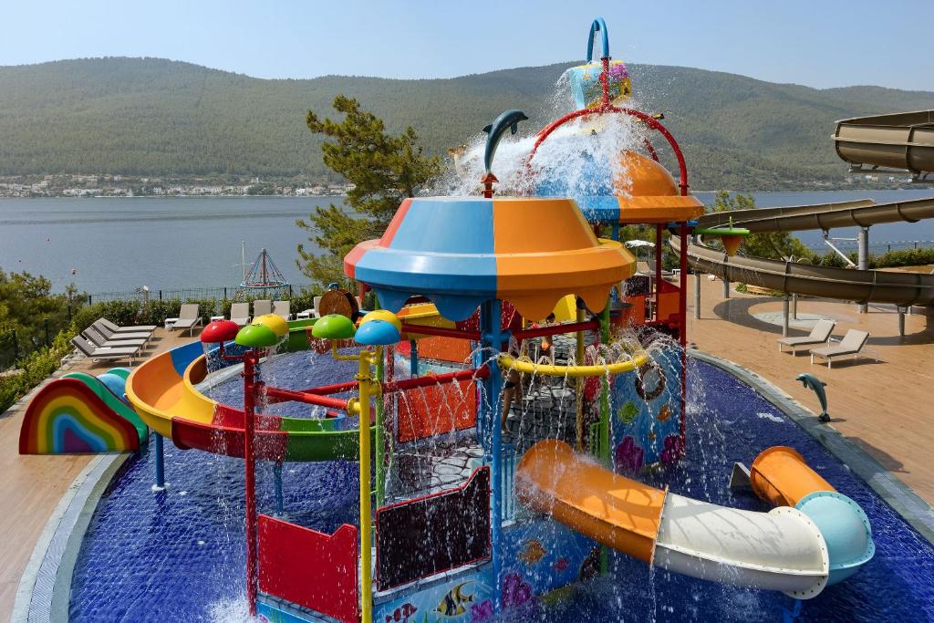 Pishina e femijeve me rreshqitese te Titanic Luxury Collection Bodrum, me gjirin ne sfond